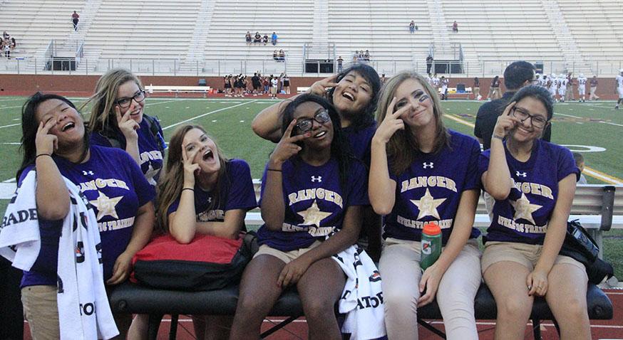 Some of the student athletic trainers pause from their work to make a silly pose for the camera before a football game. Photo by Nicholas Alvarez