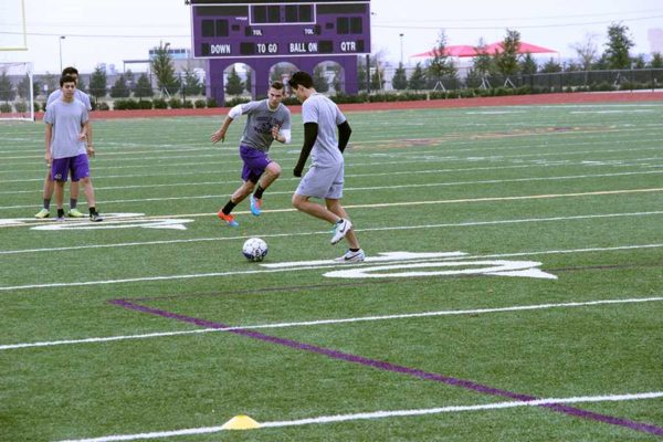 Senior Fredi Estrada and junior Noah Bankston practice crossing during varsity soccer practice Monday.  Photo by Kedar Collins.
