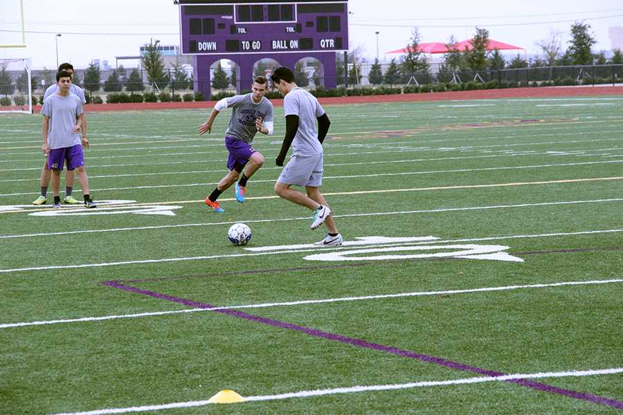 Senior Fredi Estrada and junior Noah Bankston practice crossing during varsity soccer practice Monday.  Photo by Kedar Collins.
