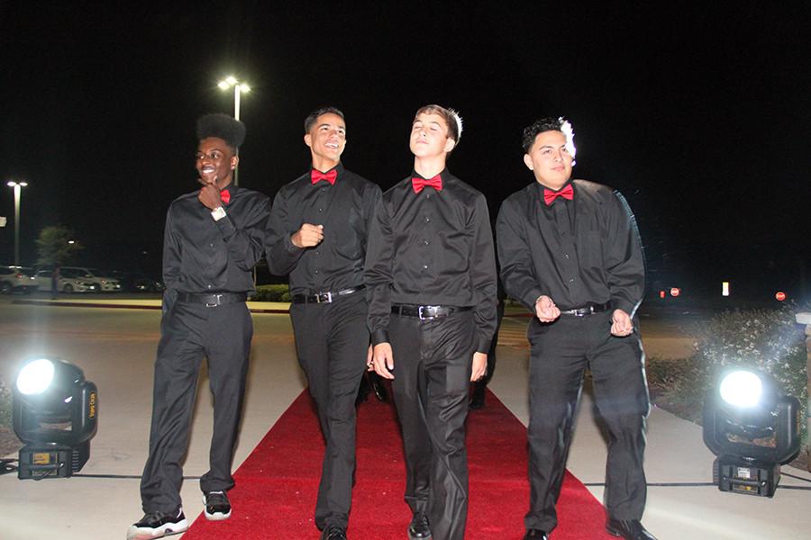 In matching outfits, juniors Donavin Arin, Tra'vel Davis, sophomore Matthew Powell, and junior Josh Rodriguez put on a show for the paparazzi at the dance red carpet. Photo by Nick Alvarez