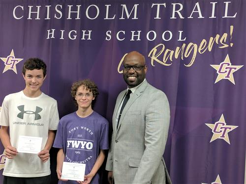 Logan Miertschin and Justyn Epps stand with Principal Berringer as they recieve their letters of Commendation from the National Merit Scholarship Corporation.