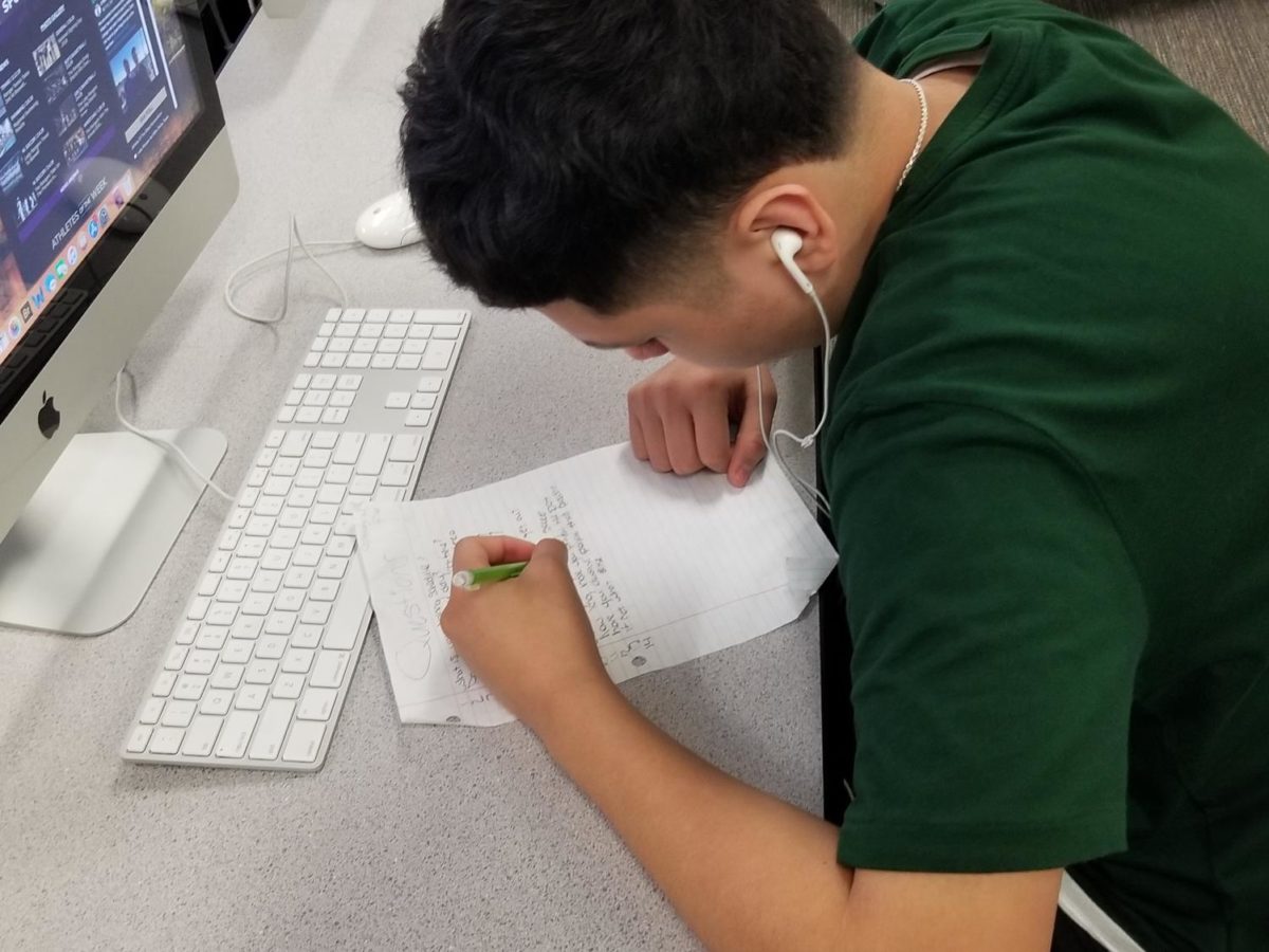 Freshman Cristian Navarro works in second period journalism class.