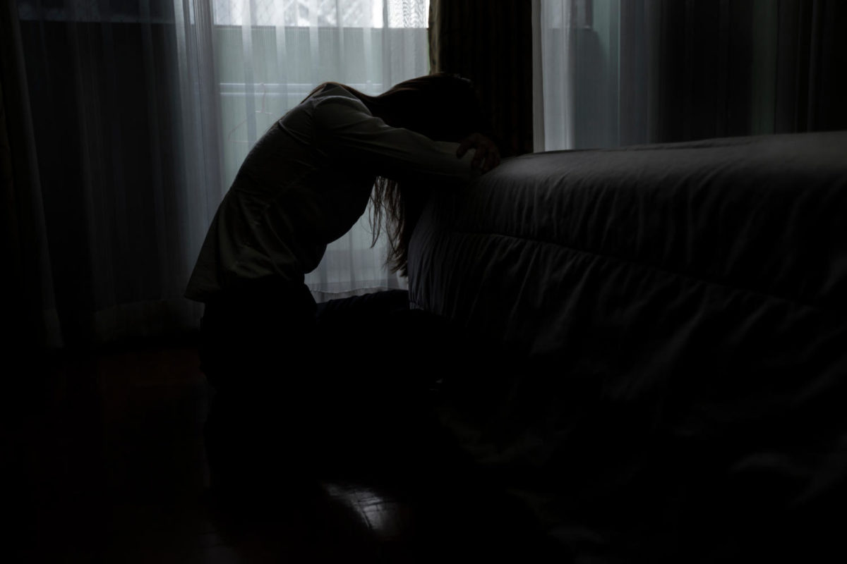 Sad young woman sitting on the bed in the bedroom, People with depression concept. Photo by SOMKID
