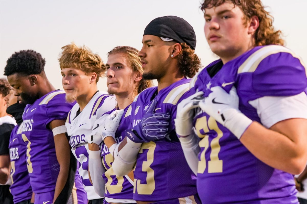 Members of the Varsity Football team stand at attention while the national anthem plays before the Homecoming Game on Sept. 27. 