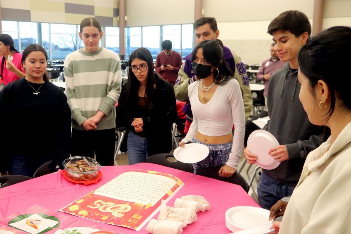 A group of students listen to an explanation of a Vietnamese gambling game before they play.