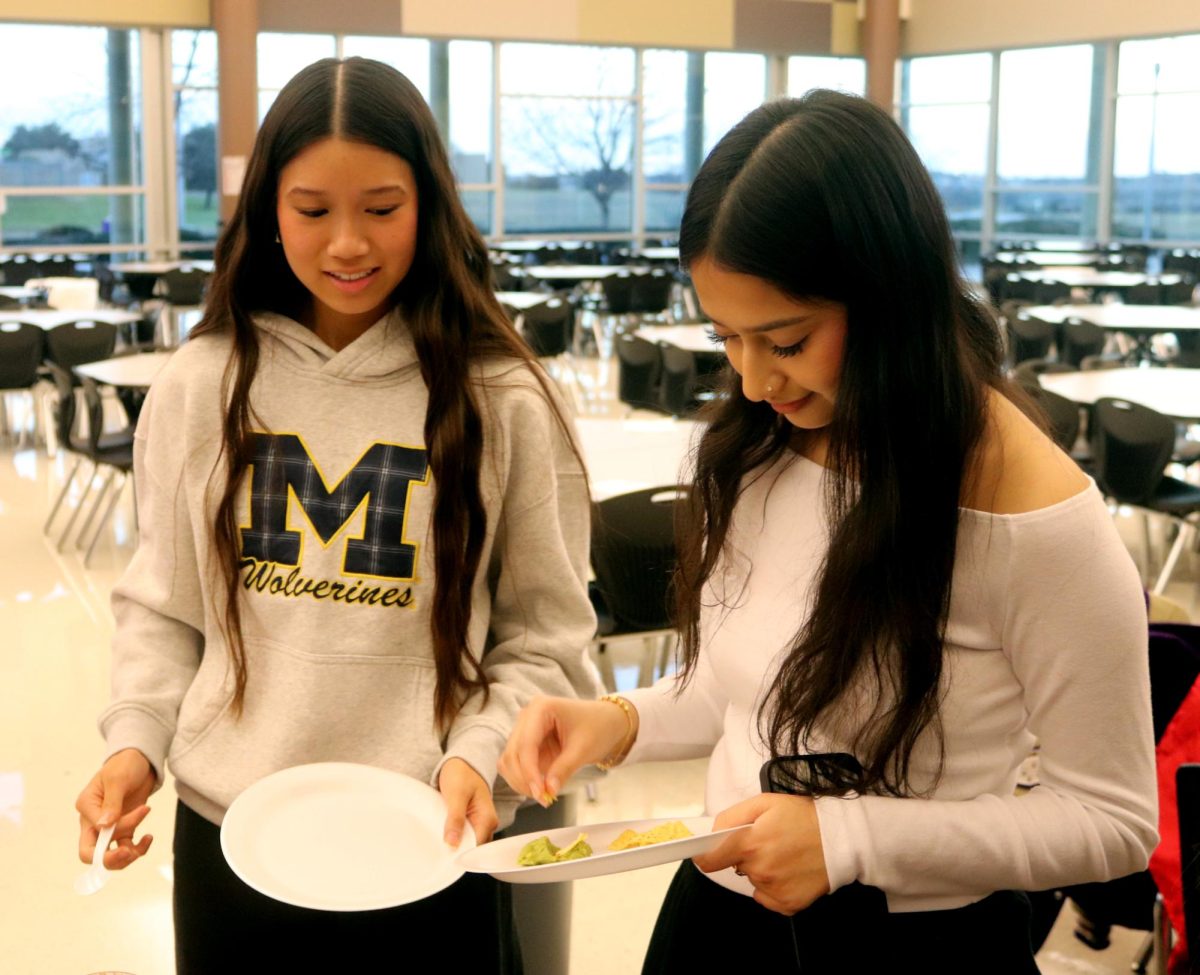 GRADE NAME NAME and GRADE NAME NAME serve themselves food at the American/Mexican table.