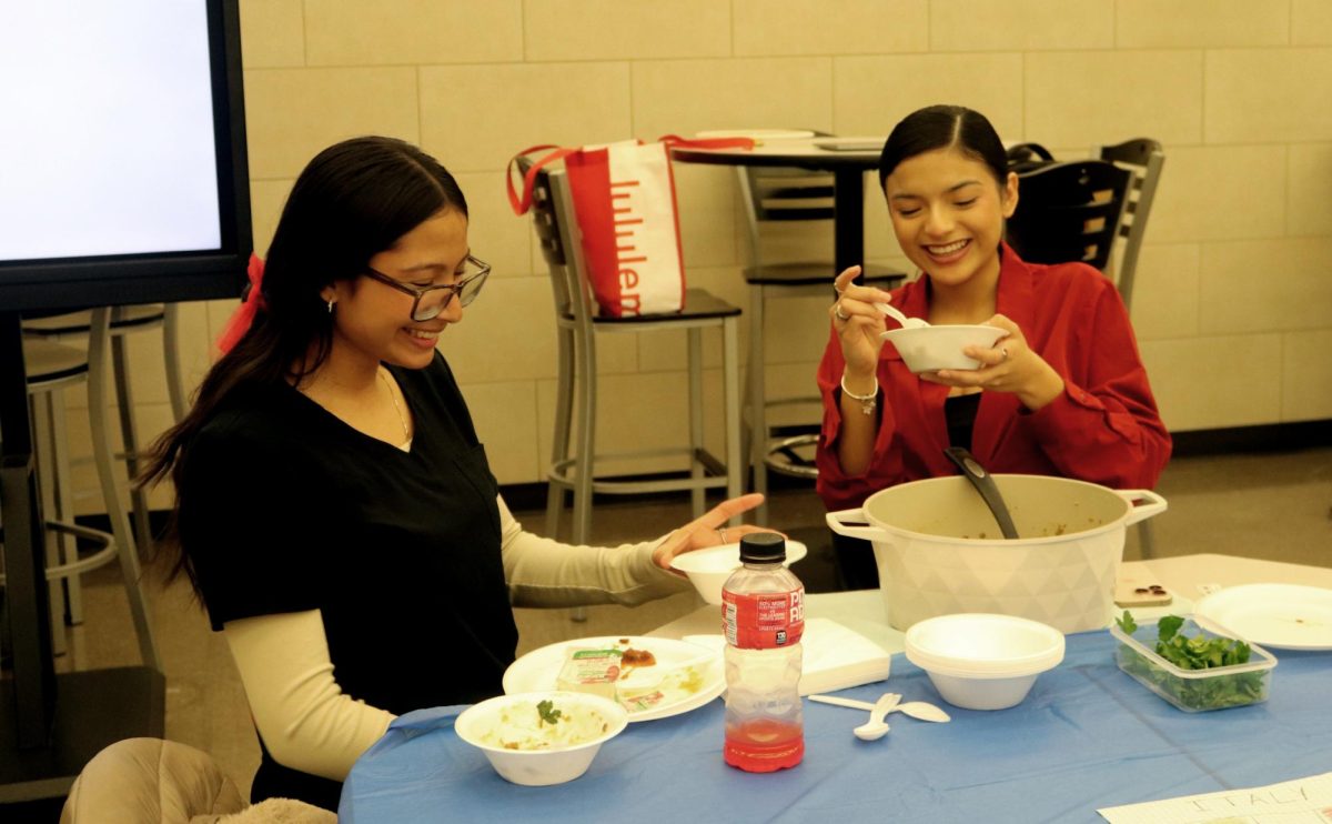 Seniors Sofia Mandonold and Naomi Montez talk while eating lentils they made for their table. 